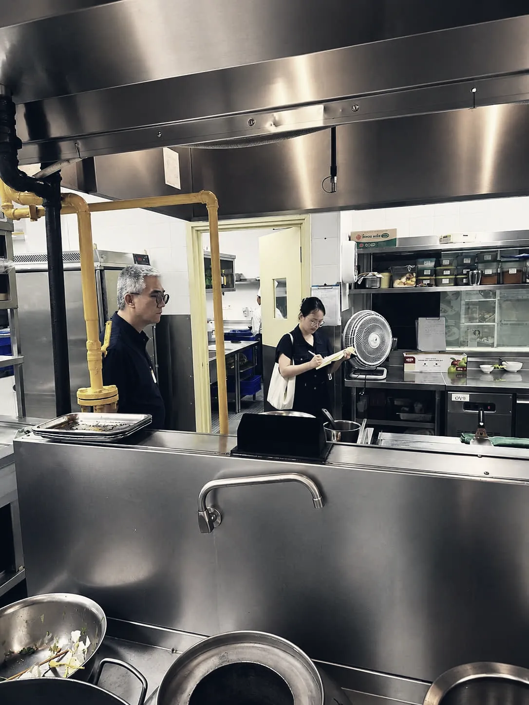 Engineers inspecting a kitchen hood and gas line